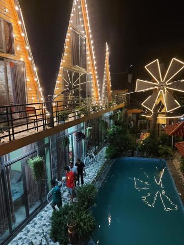 a group of people standing around a swimming pool at night at Sa Mộc House Tam Đảo - Venuestay in Vĩnh Phúc