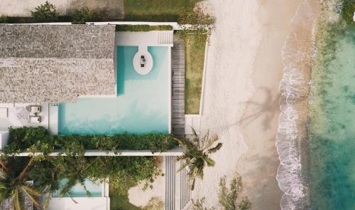 an aerial view of a resort with a swimming pool and the beach at Kimpton Kitalay Samui, an IHG Hotel in Choeng Mon Beach