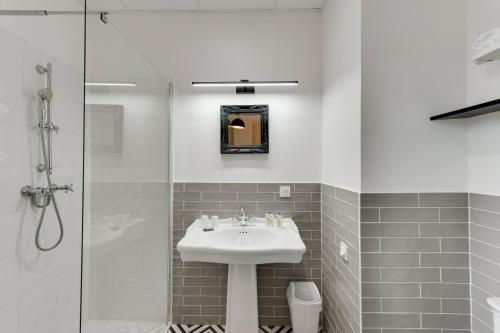 a bathroom with a sink and a shower at Le Pavillon des Fleurs in Menthon-Saint-Bernard