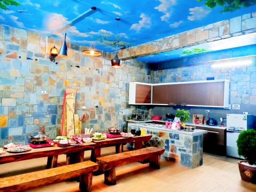 a kitchen with a table and benches in it at Sa Mộc House Tam Đảo - Venuestay in Vĩnh Phúc