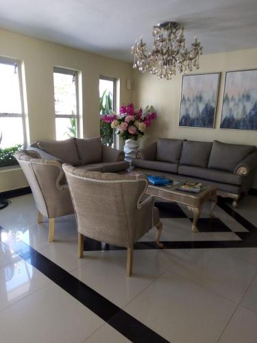 a living room with a couch and chairs and a table at Hotel Prado Real in Barranquilla