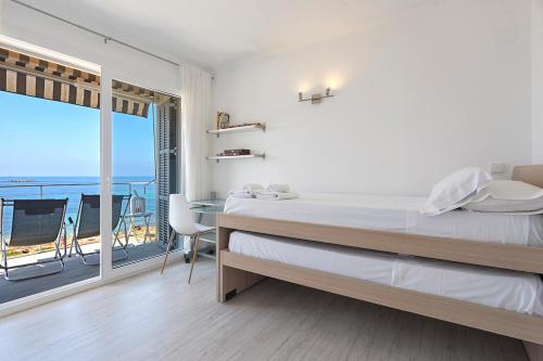 a bedroom with a bed and a view of the ocean at APARTMENT SES BAULES in Colonia Sant Jordi