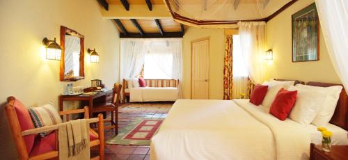 a bedroom with a bed and a desk and a room at Sarova Lion Hill Game Lodge in Nakuru