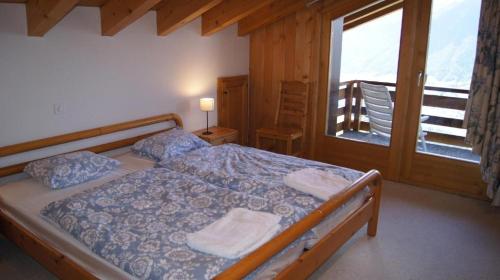 een slaapkamer met een bed met twee handdoeken erop bij Antika 215 in Verbier