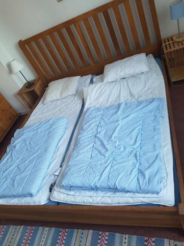 a bed with blue sheets and pillows on it at Furudals Vandrarhem och Sjöcamping in Furudal