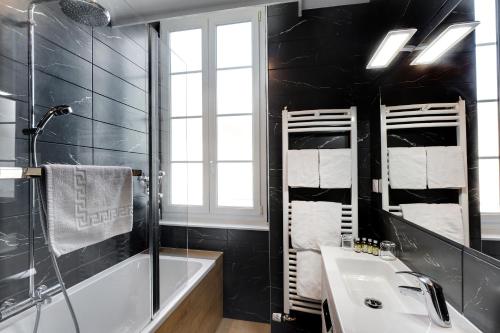a bathroom with a tub and a sink and a shower at Hôtel de France in Montmarault