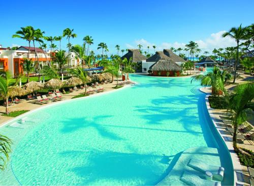 a large swimming pool at a resort with palm trees at Breathless Punta Cana Resort & Spa - Adults Only in Punta Cana
