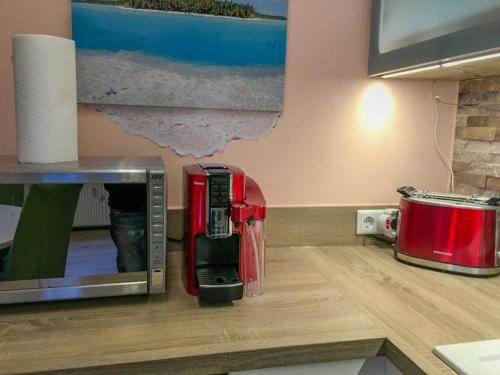 une cafetière rouge assise au-dessus d'un comptoir dans l'établissement Serviced Apartement Xanthurus, à Schwelm