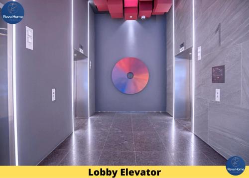 a hallway with a red and blue disk on the wall at Revo Home at Pavilion Bukit Jalil in Kuala Lumpur