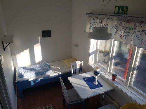 a small room with a small bed and a table at Furudals Vandrarhem och Sjöcamping in Furudal