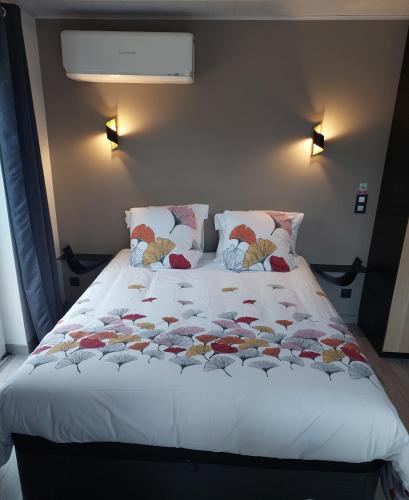 a large bed with pillows and a blanket on it at La chambre des Onglous in Marseillan