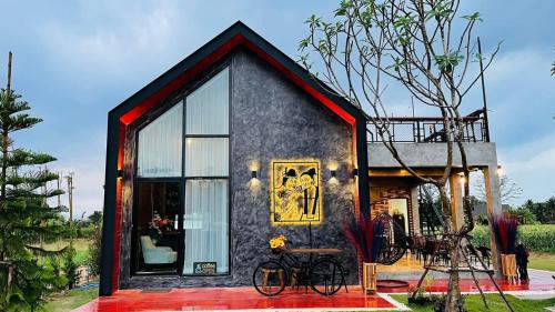 a tiny house with a large window and bikes outside at ก๋างโต้ง คอฟฟี่รีสอร์ท in Ban Na Kham