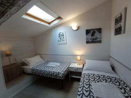 Cette petite chambre comprend 2 lits et une fenêtre. dans l'établissement Rori Apartment, à Florence