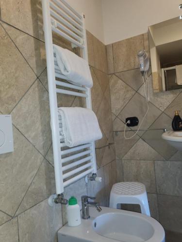 a bathroom with a sink and a toilet and towels at Rainbow Sweet Rooms in Valmontone