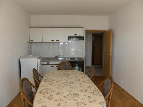 a kitchen with a table and chairs and a kitchen with a table and a table at Apartments IVAN in Duce (900) in Duće