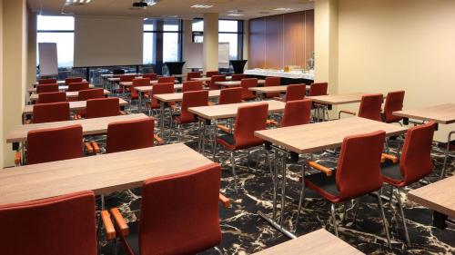 an empty lecture room with desks and chairs at Odyssey ClubHotel Wellness & SPA Adults Only in Kielce
