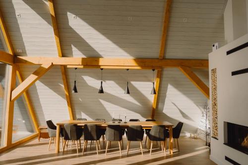 a dining room with a wooden table and chairs at Treeline Cabins in Cădăreşti