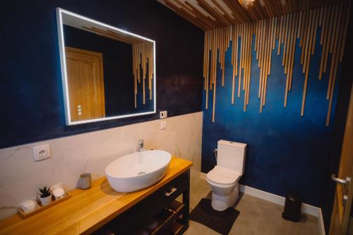 a bathroom with a sink and a toilet and a mirror at Treeline Cabins in Cădăreşti