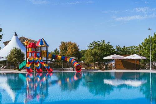 a slide in the middle of a swimming pool at Vigna sul Mar Family Camping Village in Lido di Pomposa