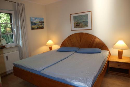 アーレンスホープにあるOSTSEEBAD-AHRENSHOOP-Haus-Deichblick-Ferienwohnung-Corinthのベッドルーム1室(青い枕のベッド1台付)