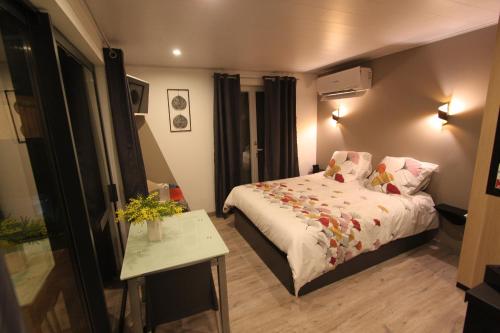 a small bedroom with a bed and a table at La chambre des Onglous in Marseillan