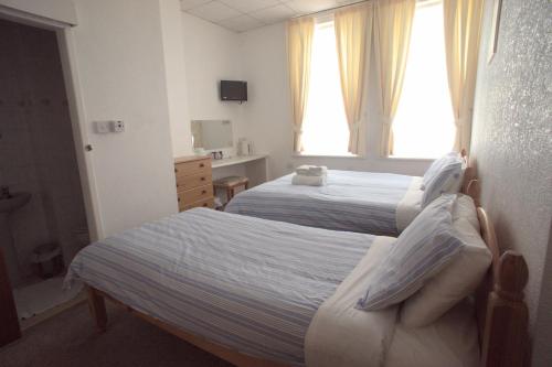 a hotel room with two beds and a window at Morrisy House in Blackpool