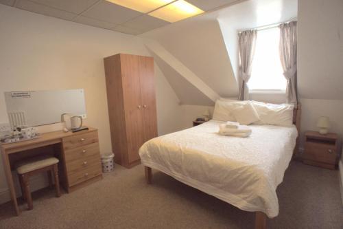 a bedroom with a bed and a dresser and a window at Morrisy House in Blackpool