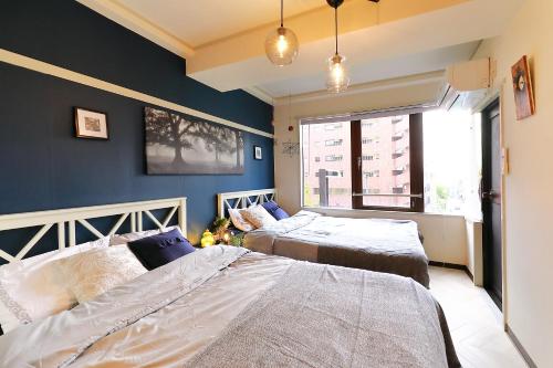 two beds in a room with blue walls at Yotsuya Matsumoto Hotel in Tokyo