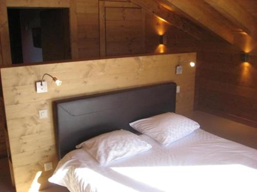 uma cama num quarto com uma parede de madeira em Port Croz Haut em Verbier