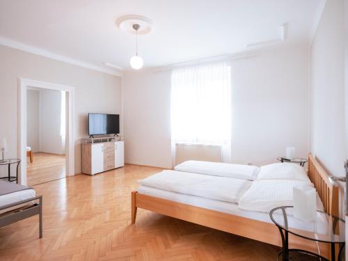 a white bedroom with a large bed and a television at Villa Sonnenschein in Laa an der Thaya