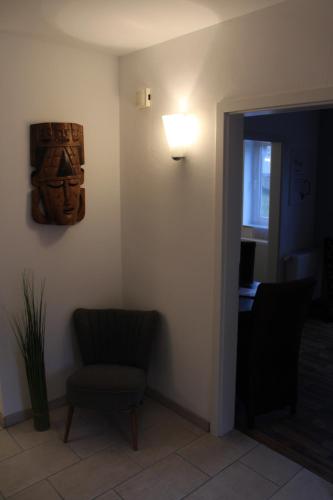 a room with a chair and a light on the wall at Appartement Luna in Ruppach-Goldhausen
