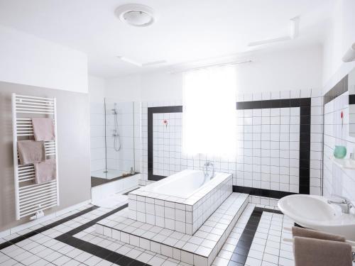 a white bathroom with a tub and a sink at Villa Sonnenschein in Laa an der Thaya
