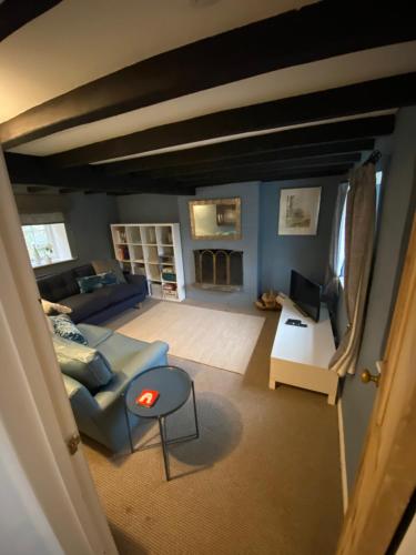 a living room with a couch and a table at The Cottage in Sulgrave