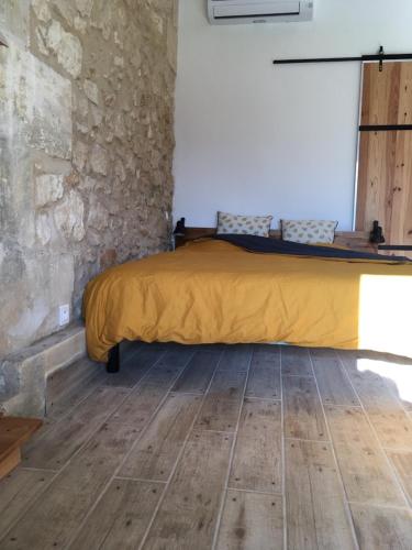 une chambre avec un lit avec une couverture jaune dans l'établissement Maison Aubergerac, à Bergerac