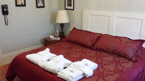 a bedroom with a red bed with towels on it at Centralia Square Grand Ballroom and Vintage Hotel in Centralia