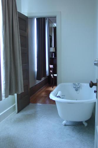 a white bath tub in a bathroom with a mirror at Centralia Square Grand Ballroom and Vintage Hotel in Centralia