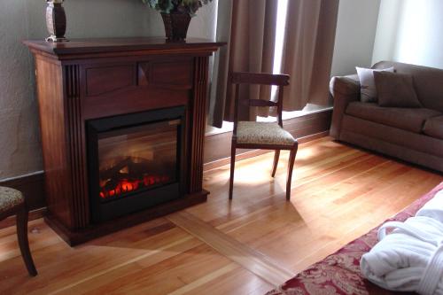 a living room with a fireplace and a couch at Centralia Square Grand Ballroom and Vintage Hotel in Centralia