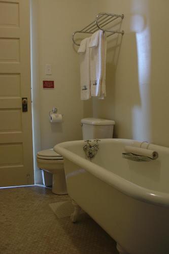 a bathroom with a white tub and a toilet at Centralia Square Grand Ballroom and Vintage Hotel in Centralia