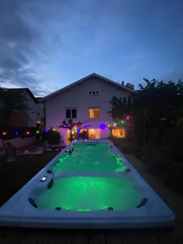 - une grande table de poker vert devant une maison la nuit dans l'établissement Espace Beléverte Bussière 1 Tamaris appartement meublé de 2 chambres, à Oullins