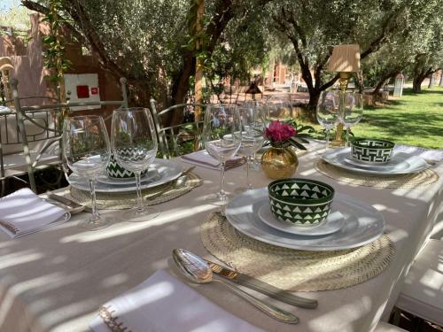 a table with plates and glasses on a table with trees at CASA ABRACADABRA in Marrakech