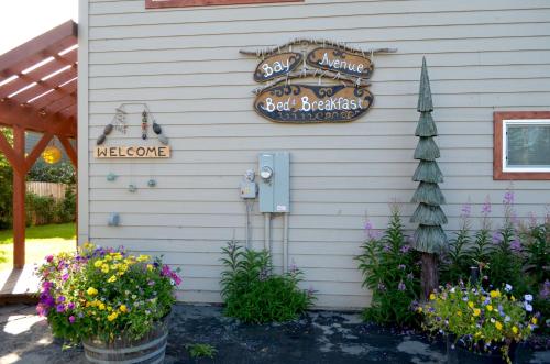 a sign on the side of a house with flowers at Bay Avenue Inn in Homer