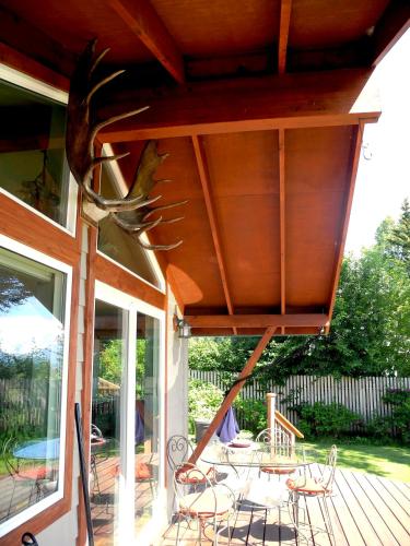 awning over a porch with a table and chairs at Bay Avenue Inn in Homer