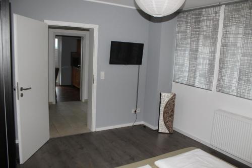 a hallway with white walls and a television on the wall at Appartement Luna in Ruppach-Goldhausen