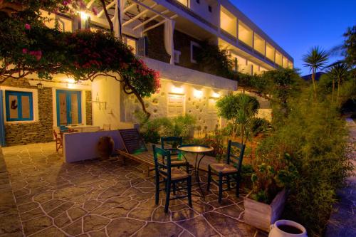 a patio with chairs and a table in front of a building at Platys Gialos Hotel Sifnos in Platis Yialos Sifnos