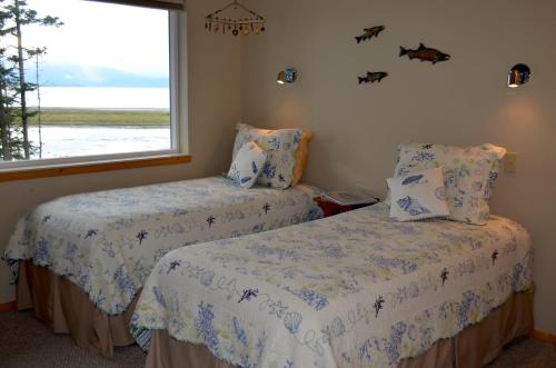 two beds in a room with a window at Bay Avenue Inn in Homer