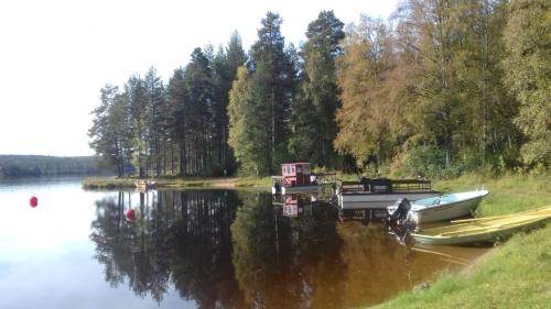 a boat is parked on the side of a lake at Furudals Vandrarhem och Sjöcamping in Furudal