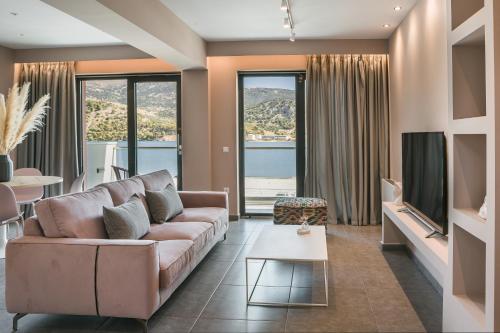 a living room with a couch and a tv at The Twelve Suites Collection in Argostoli
