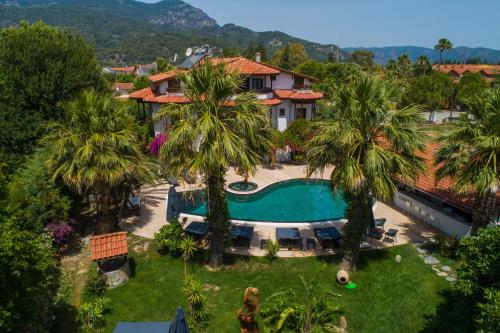 an aerial view of a house with a swimming pool and palm trees at Murat Pasha Mansion in Dalyan