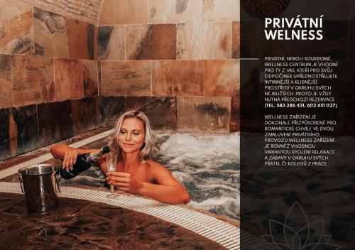 a woman in a bath tub with a blow dryer at Kolštejn wellness centrum in Branná