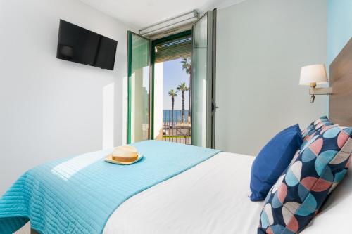 a bedroom with a bed with a hat on it at Kronos on the Beach suite 1 in Barcelona
